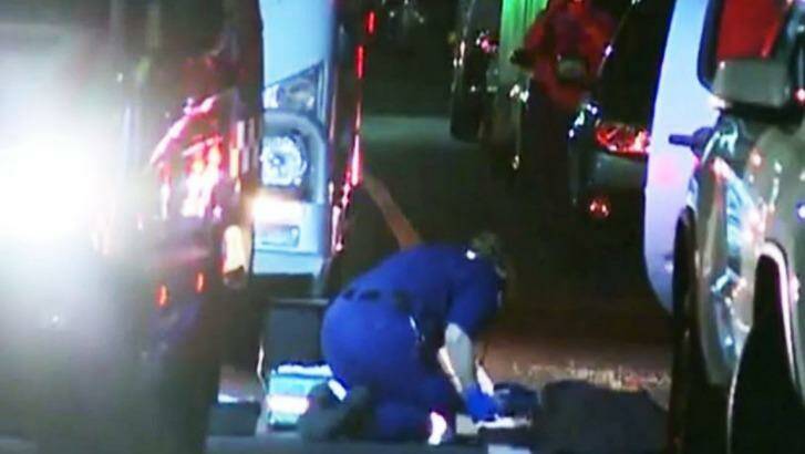 Paramedics treating Sung Sub Kim, who was found bound and injured on Dean Street in Strathfield.  Photo: Nine News