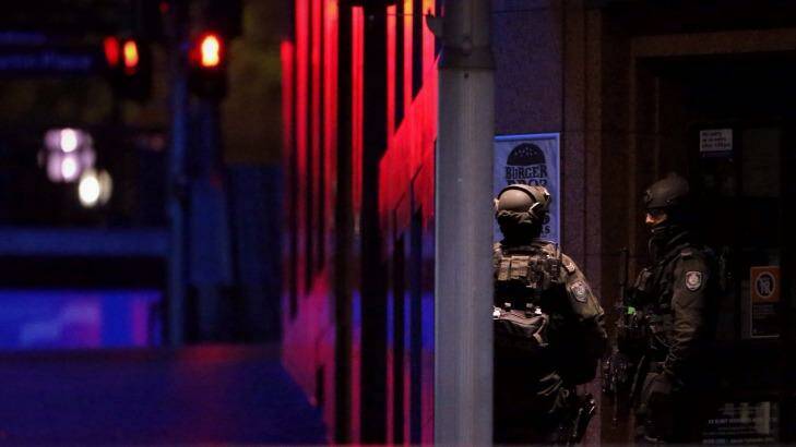 Tactical operations unit police keep watch before the first loud noise was heard. Photo: Andrew Meares