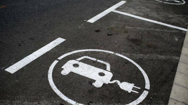 Road signs mark parking bays for drivers to use electric vehicle charging points in Spain, Photo: Pau Barrena