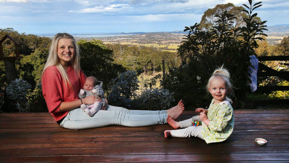 Ruthie Lawson is all smiles on the verandah of her home where she gave birth to her second child, Velvet, during a howling gale. With her is 21-month-old daughter Indie. Picture: KIRK GILMOUR
