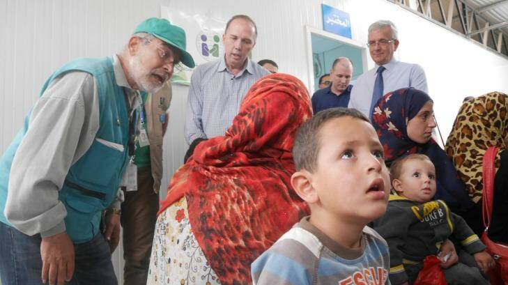 Immigration minister Peter Dutton talks to a refugee family at a medical clinic at camp. Photo: Nick Miller