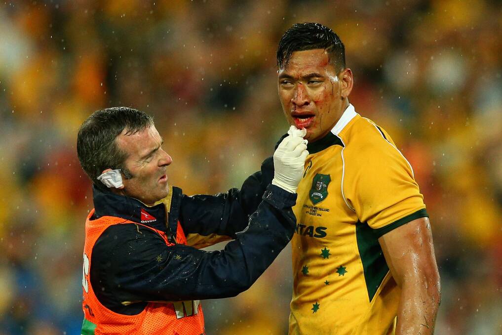 Israel Folau is treated after he collided with teammate Nic White while both were chasing a kick. Picture: GETTY IMAGES