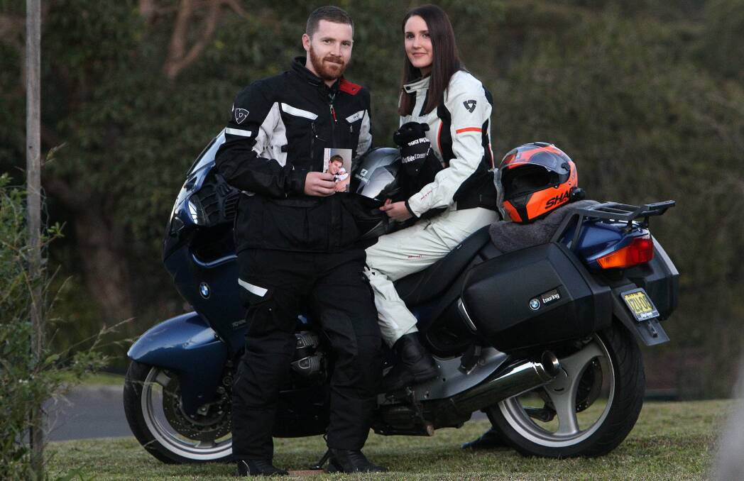 Ready to ride: Marcus Wiltshire and his partner Emma Baker on their motorcycle. Marcus is holding a pic of Mitchell Howard. Picture: GREG TOTMAN