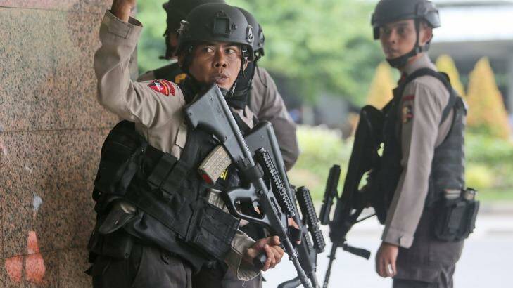 A police officer gives a hand signal to a squad mate as they search a building near the site of an explosion in Jakarta, Indonesia Thursday, Jan. 14, 2016.  Attackers set off explosions at a Starbucks cafe in a bustling shopping area of downtown Jakarta and waged gun-battles with police Thursday, leaving bodies in the streets as office workers watched in terror from high-rise windows. (AP Photo/Tatan Syuflana) Photo: Tatan Syuflana