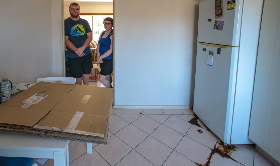 Back in: Heath and Rachel Byrne inspect the damage in their Miller Street apartment. Picture: ADAM McLEAN