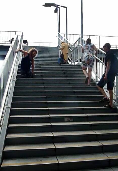 Unacceptable: Double amputee Toby Lyndon has to crawl up the Unanderra station steps.