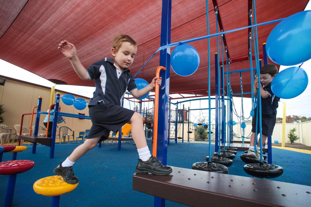 Liam Gondek and Philip Brown test out the new playground at the Aspect South Coast School. Picture: ADAM McLEAN