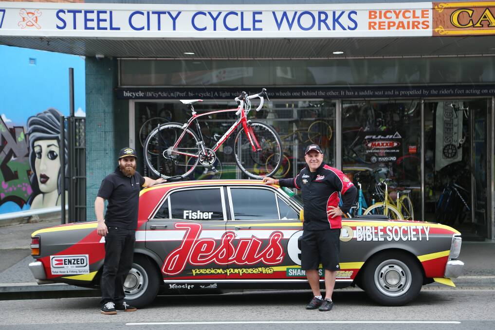 Driven: Supporter Ross Thomas, of Steel City Cycle Works, with Andrew Fisher and his Touring Car Masters race car. The Jesus Racing Team is completely Wollongong based this year.Picture: GREG ELLIS