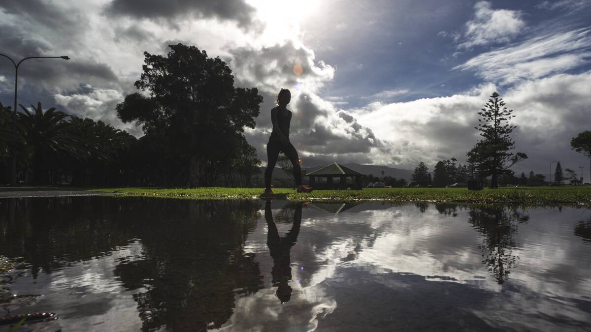 A walker picks her way around a flooded area in Stuart Park on Friday. Picture: CHRISTOPHER CHAN