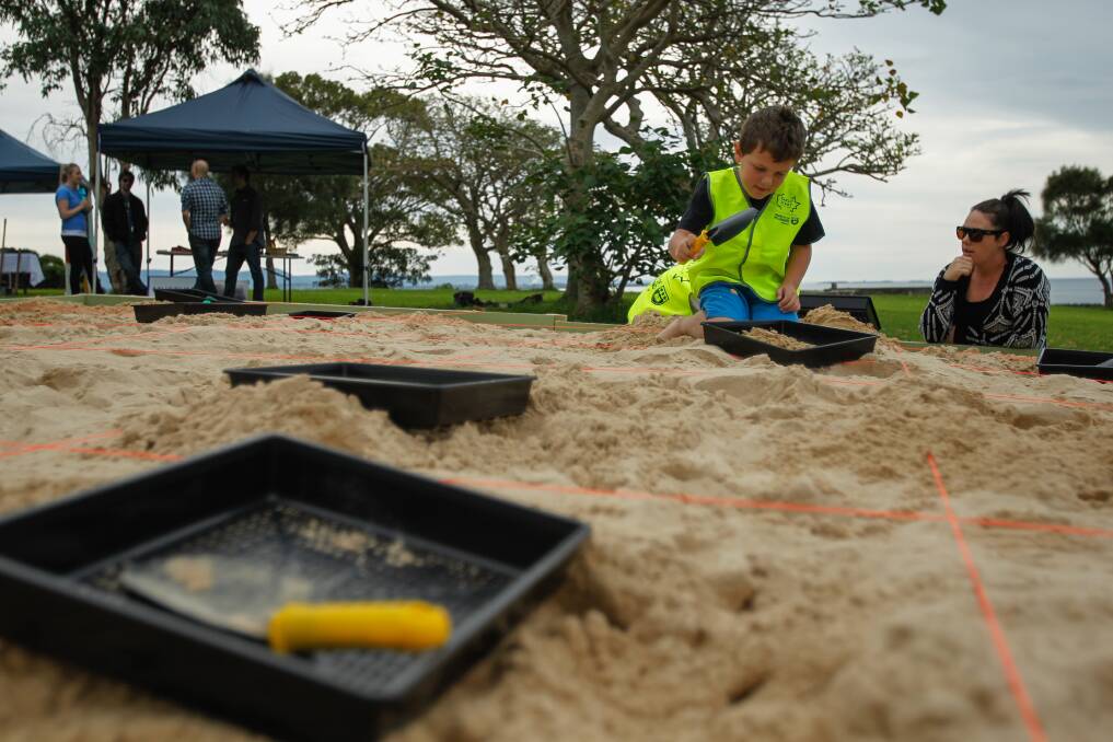 Tyler Hogg, 8, excavates "artefacts" and identifies them as part of Kidsfest at Killalea State Park. Picture: CHRISTOPHER CHAN
