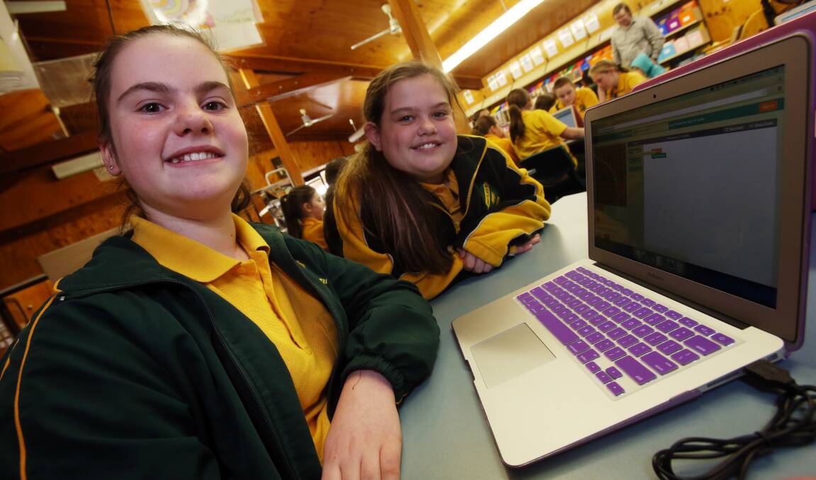 Busy bees: Oak Flats Public School students Giselle Devenney and Abi Cuthbert during one of the coding workshops.Picture: ROBERT PEET