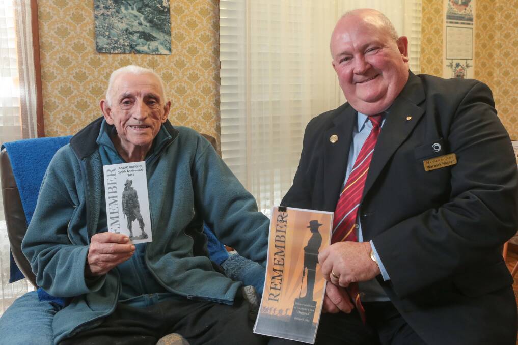 Doug Rymer and Warwick Hansen with the Anzac booklets. Picture: ADAM McLEAN
