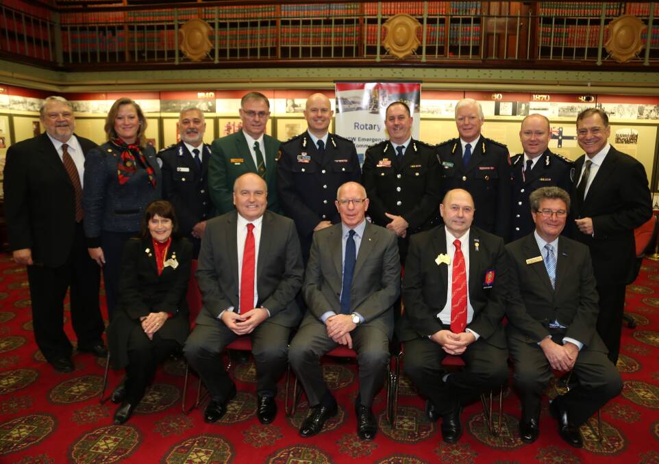 Illawarra organisers Ian and Carole Johnston (back left) with Dot Hennessy, NSW Emergency Services minister David Elliot and David Hurley (front left) with commissioners and deputy commissioners of six emergency services and master of ceremonies John Mangos. Picture: GREG ELLIS
