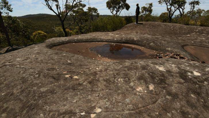 Whale and eel carvings can be seen in the foreground at Moon Rock. Photo: Kate Geraghty