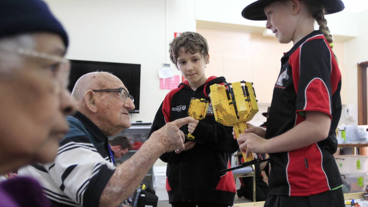 Lancel Brown, 104, discusses the trophies won by Sebastian Boswell, 11, and Katie Watson, 10, who competed at the recent international FIRST Lego League Championships.Picture: ANDY ZAKELI