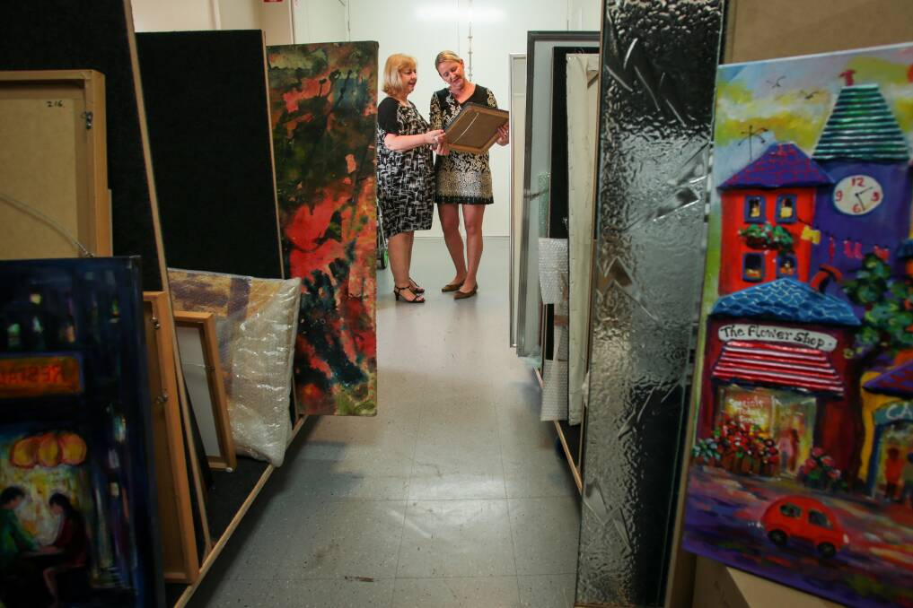 Wollongong Art Gallery Friends' Sheldri Weston (left) and Jo Duncan check out some of the art work for the Affordable Art and Artisan Markets. Picture: ADAM McLEAN
