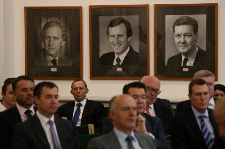 Tony Abbott listens to Prime Minister Malcolm Turnbull address the Government joint party room benaeth portraits of former Liberal leaders Andrew Peacock, John Hewson and Alexander Downer at Parliament House in Canberra on Tuesday 1 March 2016. Photo: Andrew Meares