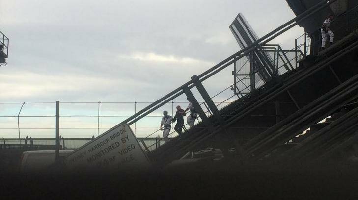 NSW Police Rescue officers escort Adrian Karibian off the Sydney Harbour Bridge. Photo: Emma Partridge 