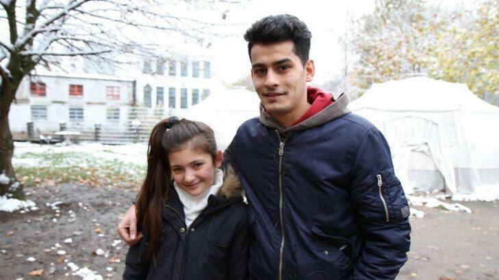 Yazidi refugee Renda Barakat, 11, with Majid Dhalriaiyam, 17, from Afghanistan outside a snow-covered refugee shelter in Germany.  Photo: Eryk Bagshaw