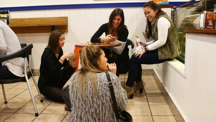 Women enjoy a meal in the floor of a pies restaurant in Newtown. Photo: Daniel Munoz
