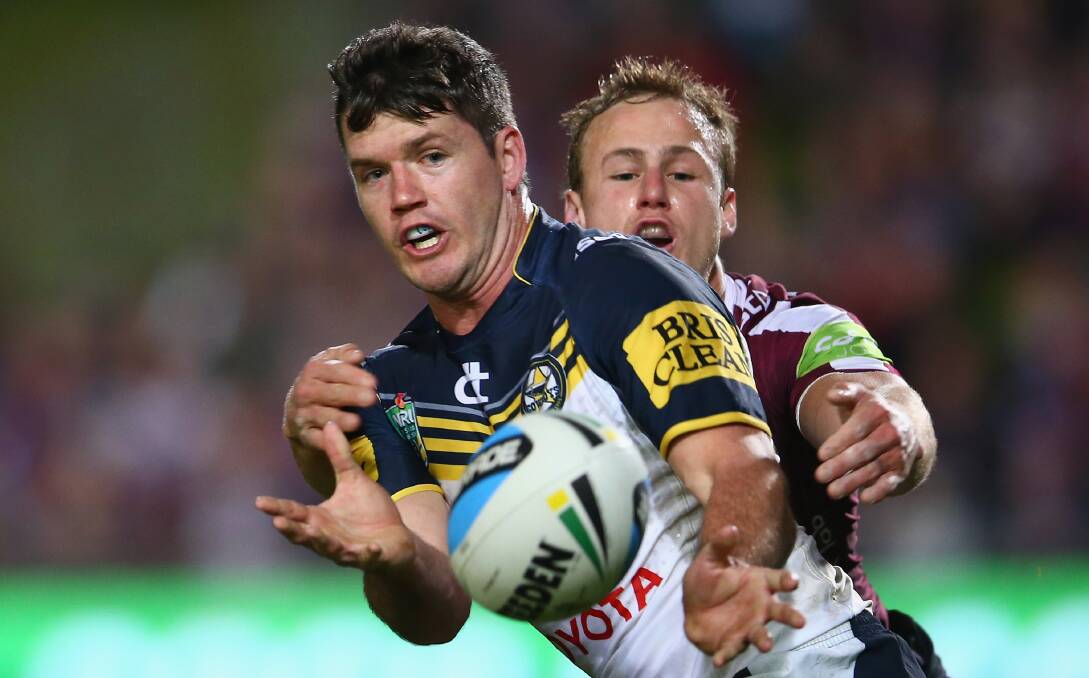 Lachlan Coote of the Cowboys passes as he is tackled by Daly Cherry-Evans of the Sea Eagles at Brookvale Oval on Monday night. Picture: GETTY IMAGES