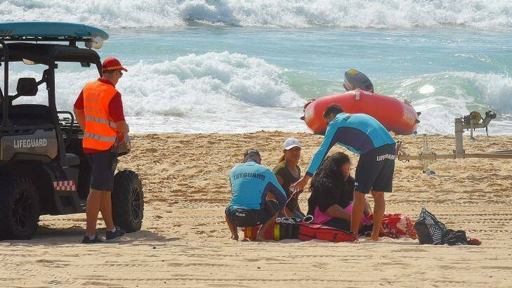 NSW Surf Lifeguards and Surf Rescue assist Tui Gallaher's mother. Photo: Kate Geraghty