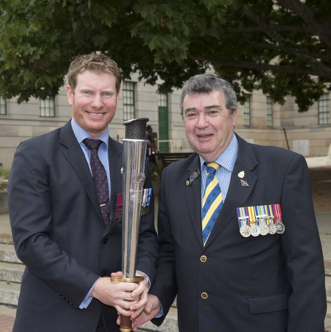 VC recipient Daniel Keighran, left, with Queanbeyan RSL Sub-Branch president Matt Helm and the RSL Anzac Flame at the Australian War Memorial in Canberra. Mr Helm was there on behalf of Wollongong RSL.