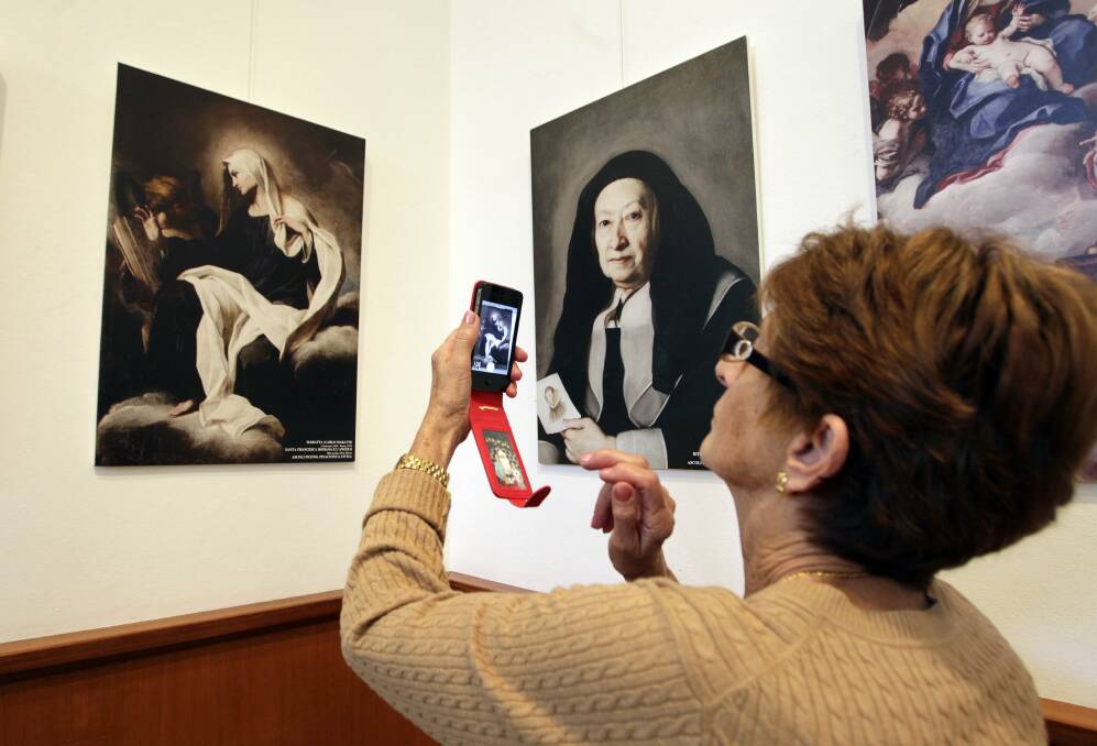 Maria Cealini takes a photo of a painting from her home region of Marche, Italy. The baroque exhibition is on at Wollongong Art Gallery. Picture: ANDY ZAKELI