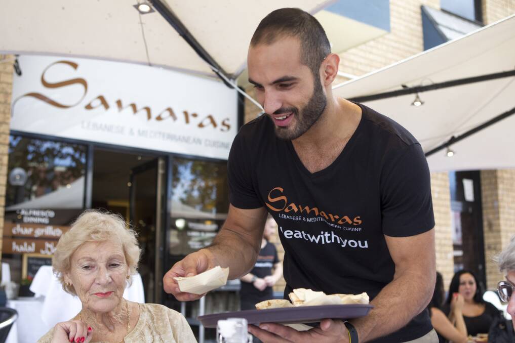 Campaign: Samara's owner Omar Nemer serves a customer at a special lunch for a campaign against racism. Picture: CHRISTOPHER CHAN