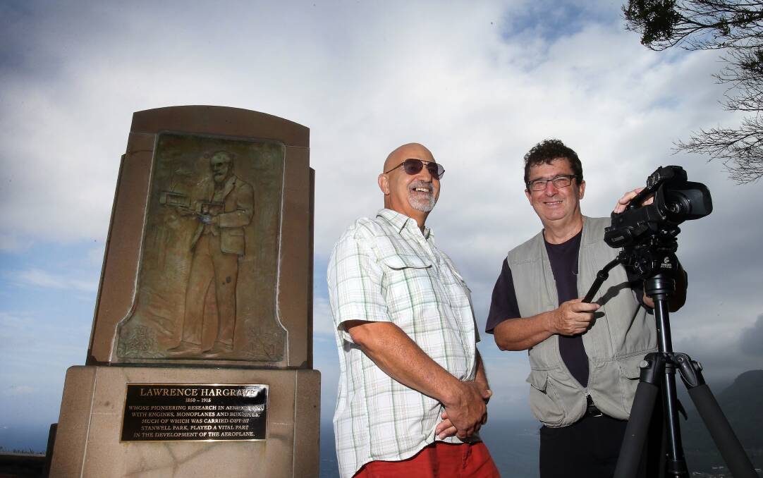 Paraglider and researcher Mark Mitsos and film-maker Geoffrey Sykes, who has directed a documentary about Lawrence Hargrave, admire the Hargrave monument at Bald Hill, Stanwell Park. Picture: KIRK GILMOUR