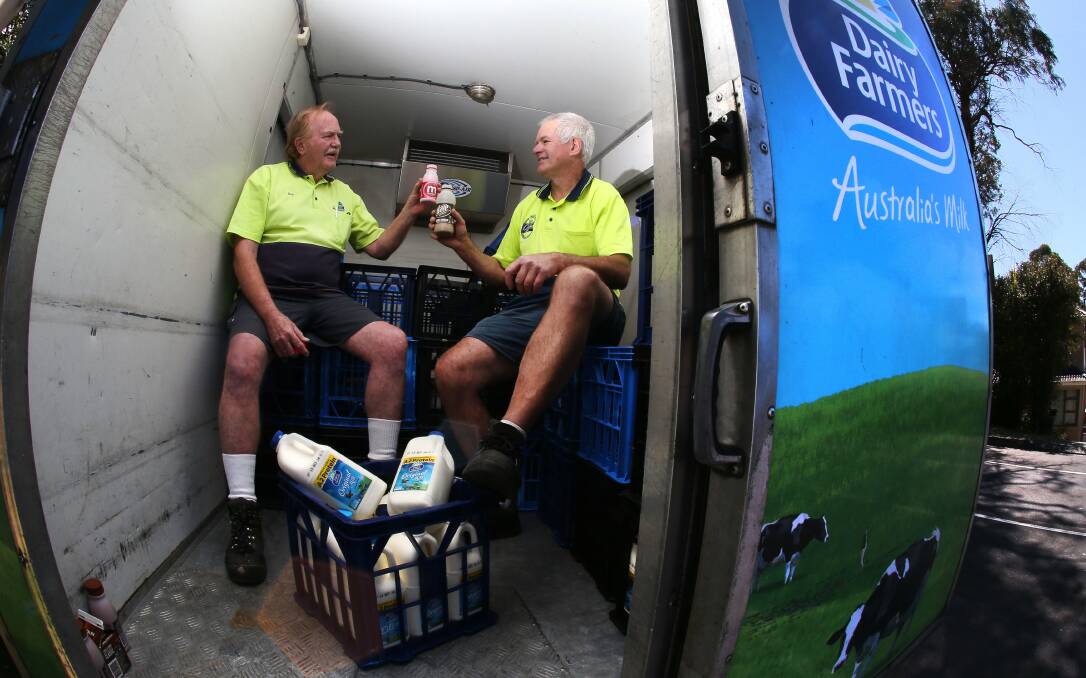 Retired milk vendor Bob Young and milko Bob Whitling toast with flavoured milk in the back of a milk truck. Picture: KIRK GILMOUR