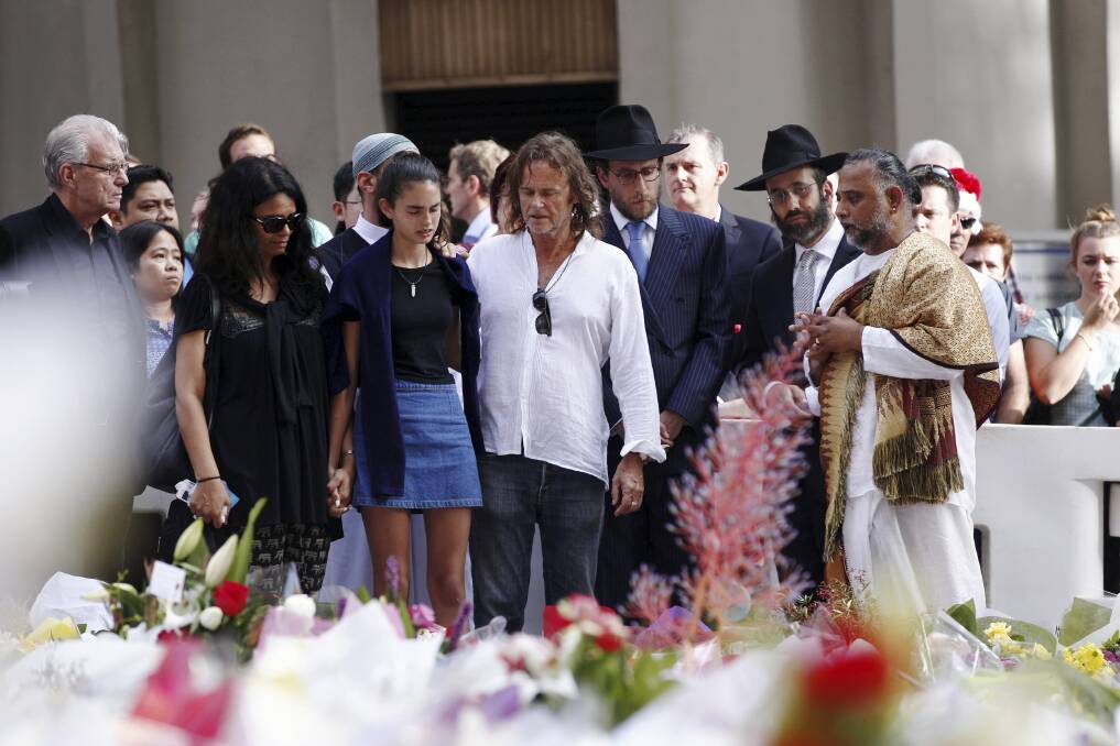 Members of Tori Johnson's family meet religious leaders at the memorial site that has become a floral tribute to both the murdered cafe manager and Katrina Dawson. Picture: JAMES BRICKWOOD
