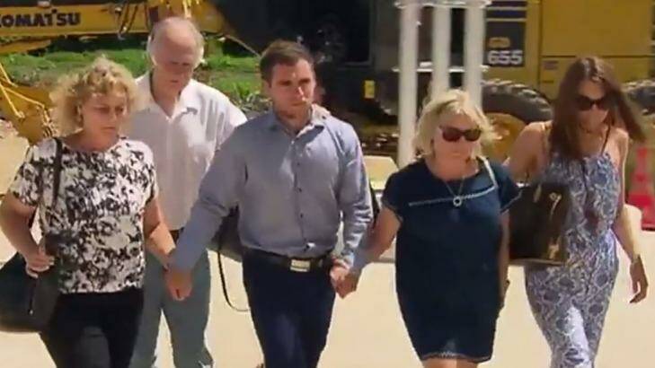Thomas Keating (centre) arriving at Phuket police station with members of his family, and the family of his late girlfriend Emily Collie. Photo: Twitter/@7NewsMelb