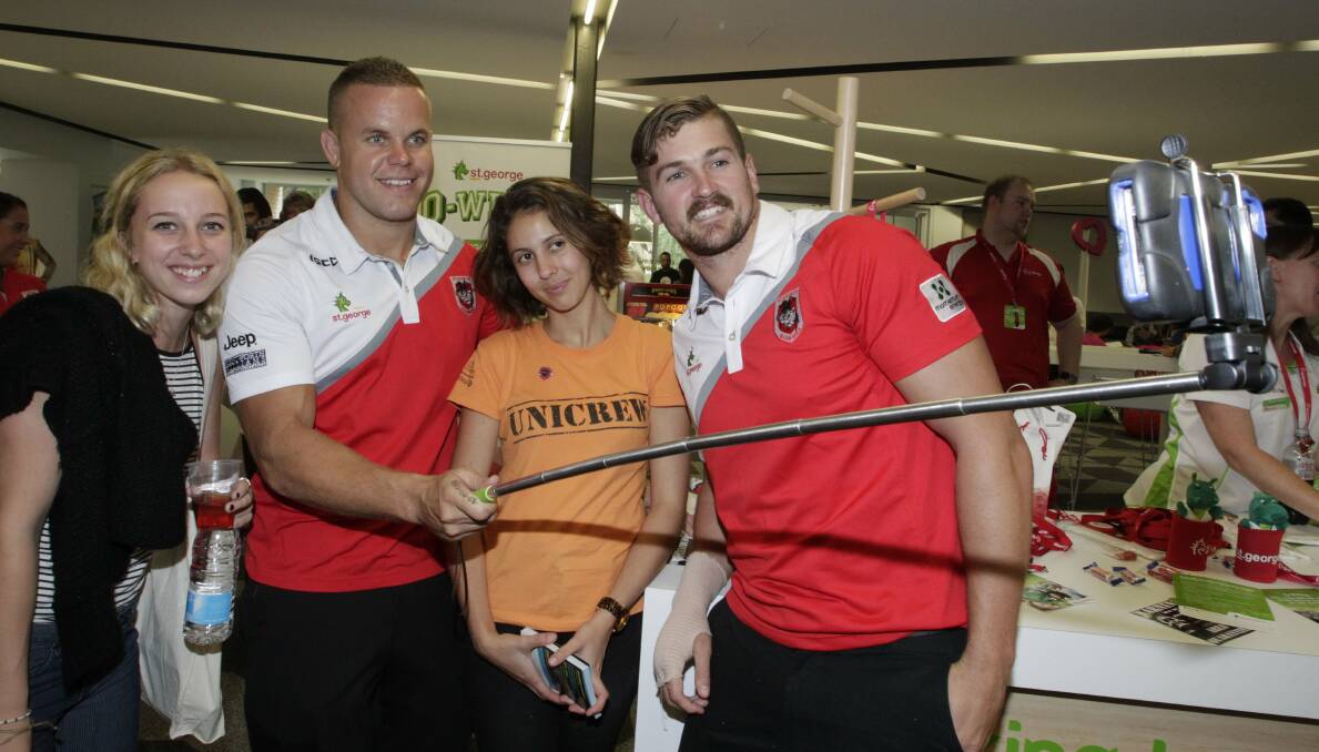 Controversial: St George Illawarra Dragons players Dan Hunt (second left) and Will Matthews (right), with Savarna Adair and Emily Tolhurst while handing out selfie sticks during the University of Wollongong's O-Week event. Picture: ANDY ZAKELI