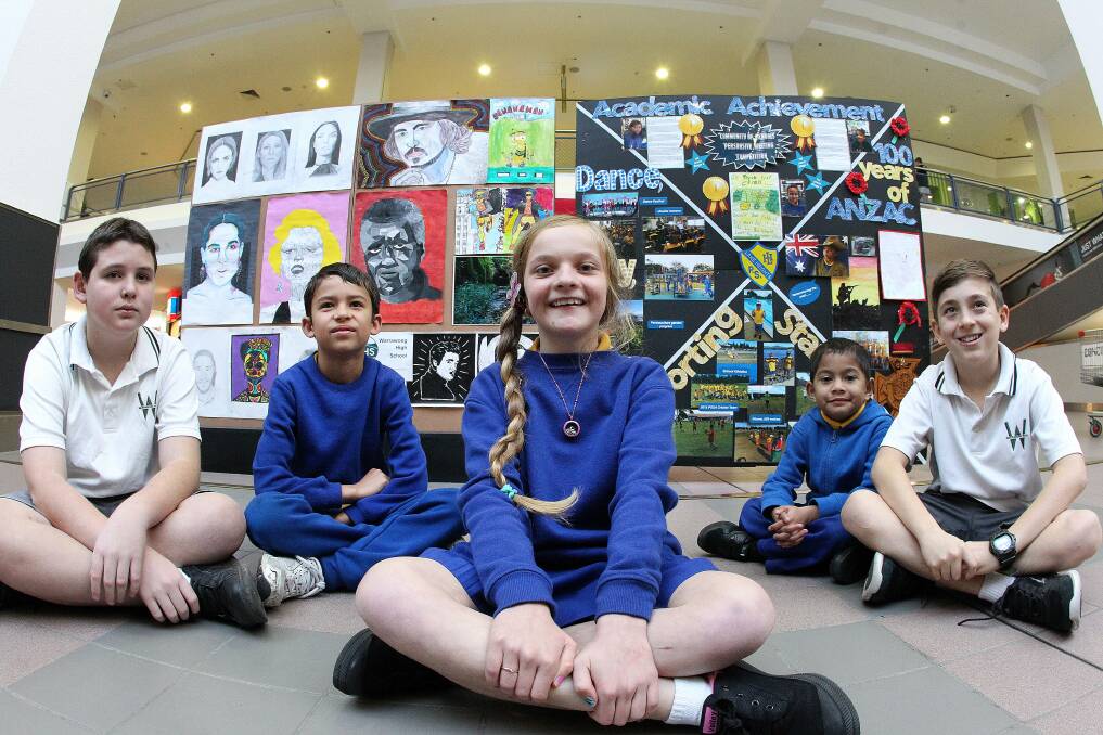 Miles Stojanovski (Warrawong High, left), Phoenix Duncan, Bronte Krstevski and Najwan Nezay (Lake Heights Public) and Dylan Alderton (Warrawong High) with some of the artworks. Picture: GREG TOTMAN
