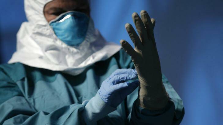 Safety first: A nurse demonstrates putting on protective clothing before dealing with an Ebola patient.