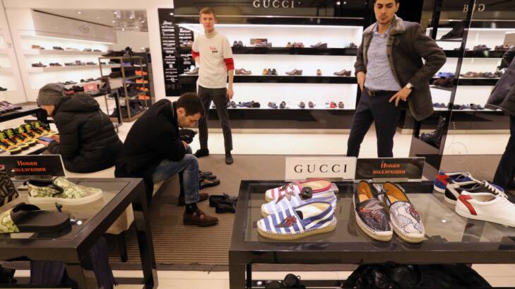 Customers try on luxury brand shoes in the TsUM department store in Moscow.  Photo: Andrey Rudakov