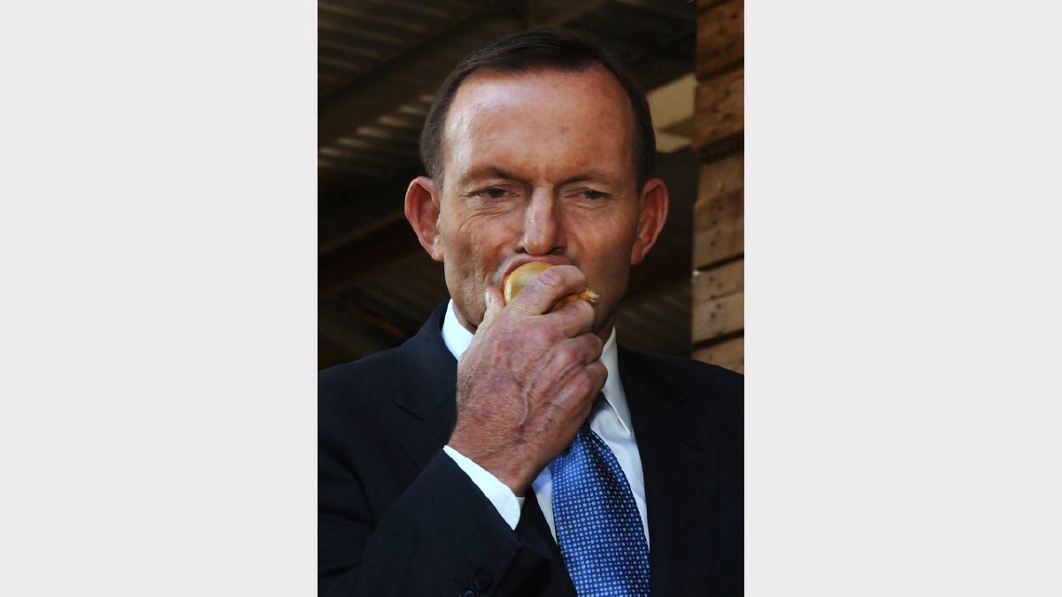 Prime Minister Tony Abbott bites into a fresh onion at the announcement of freight subsidy at Charlton Farm Produce at Moriarty. Picture: Neil Richardson