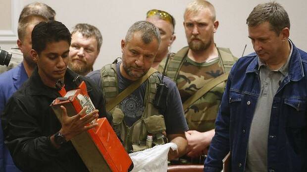 A Malaysian expert examines the MH17 black box after receiving it from pro-Russian rebels. Picture: REUTERS