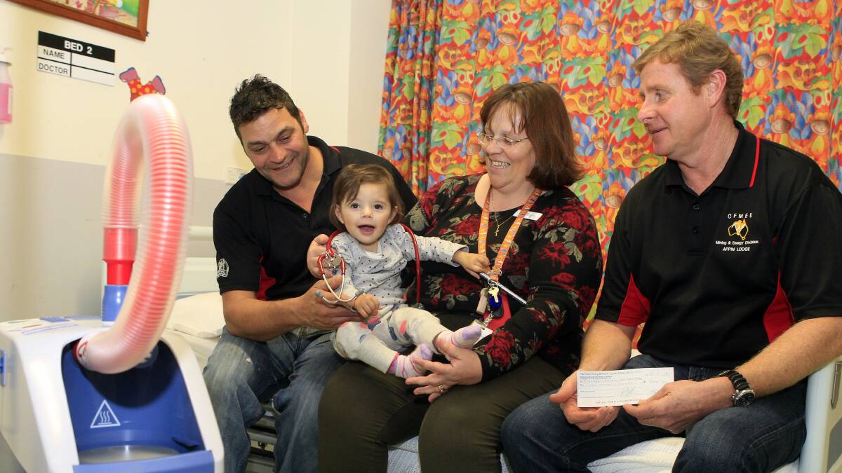 Miners Joe Sleiman and Stephen Bourke with Director of Paediatrics and Child Health Dr Susie Piper and 15-month-old Isla Rowiri at Wollongong Hospital Children’s Ward. Picture: ANDY ZAKELI