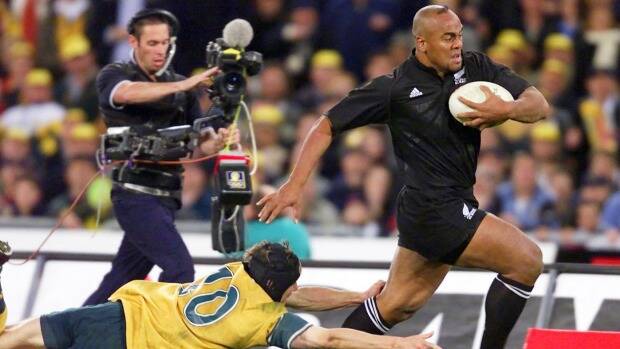 Might and power: Jonah Lomu evades Stephen Larkham during the memorable 39-35 win over the Wallabies at Stadium Australia in July, 2000. Photo: Craig Golding
