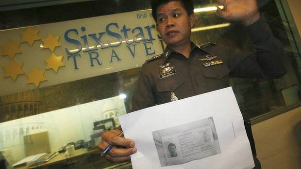 A Thai policeman shows a copy of Italian Luigi Maraldi's stolen passport. Photo: AP