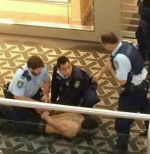 Restrained: Police subdue a man, 33, after a stabbing death at Westfield Parramatta. Photo: Channel Nine