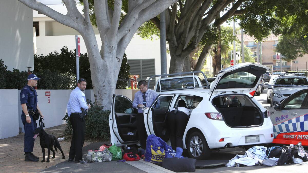Detectives inspect a car after it crashed on Blackett Street, North Wollongong on Friday. Picture: KIRK GILMOUR
