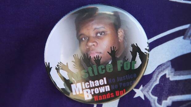 A resident wears a button featuring a picture of teenager Michael Brown, who was killed by police officer Darren Wilson on August 9. Photo: Scott Olson/Getty Images