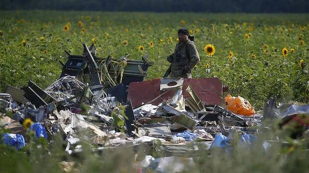 An armed pro-Russian separatist stands guard over the wreckage of MH17. Picture: REUTERS