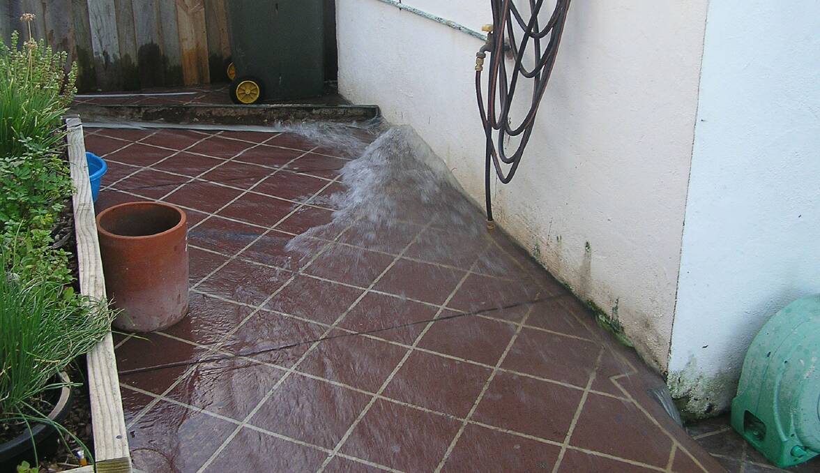 Three homes were flooded after a water main burst on Quarry Street, Port Kembla on Tuesday. Picture: BOB PARKES
