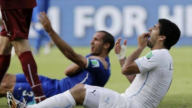 Luis Suarez holds his mouth as Giorgio Chiellini protests in the background. Photo: AP
