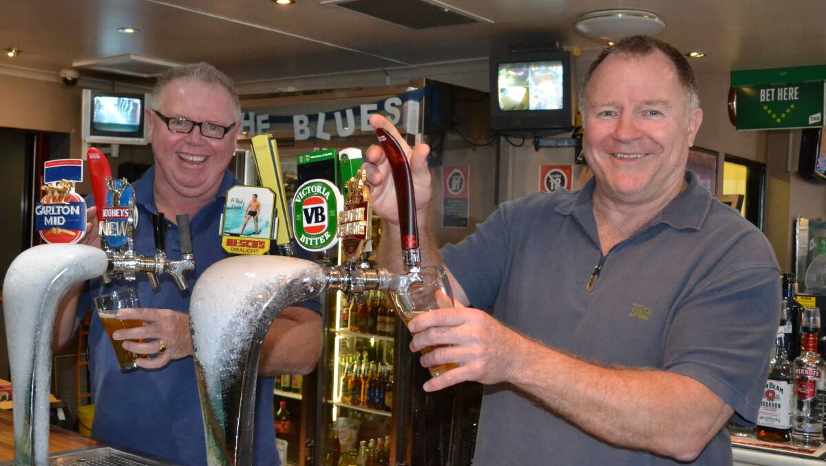 New owners of the Bomaderry Hotel, Lloyd Segerstrom (left) and former Australian rugby league representative Ian Schubert get down to work pulling beers. Picture: ROBERT CRAWFORD