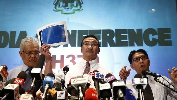 Malaysian acting Transport Minister Hishamuddin Hussein, centre, hold up maps of rescue corridors during a press conference in Kuala Lumpur. Picture: AP